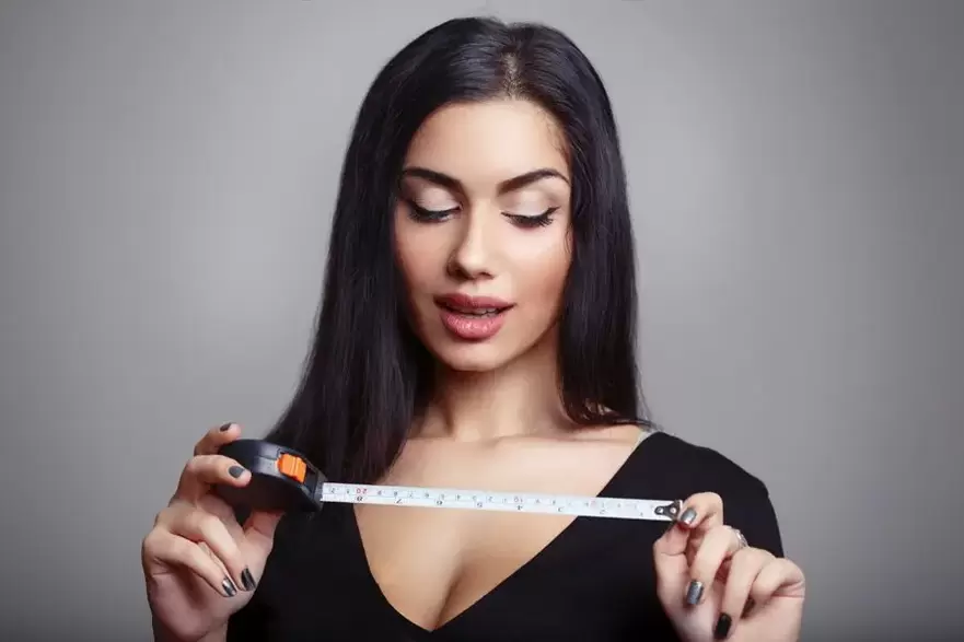 момиче със сантиметър и измерване на пениса след увеличаване на помпозността
